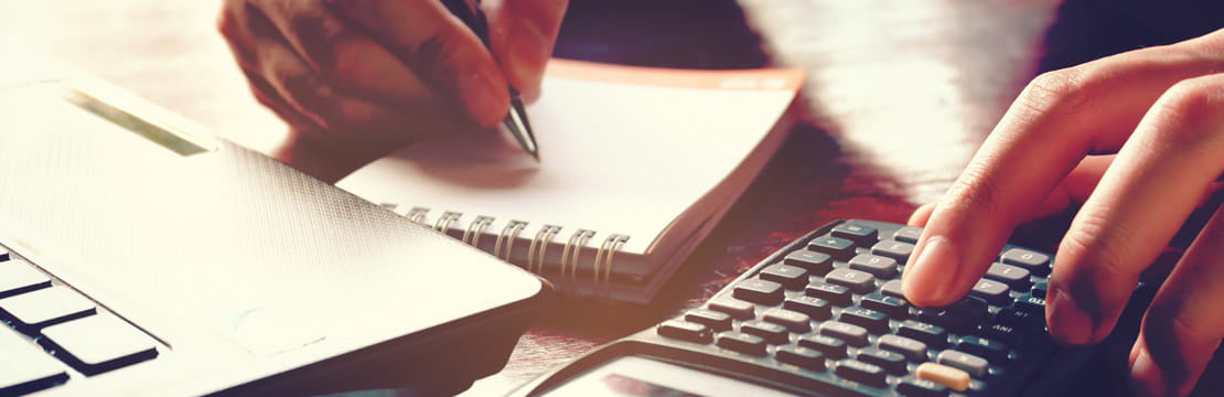 Hands of businessman working with calculator and notepad